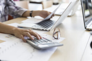 IPV- Rentennavigator– Foto einer arbeitenden Person am Schreibtisch mit Laptop und Taschenrechner