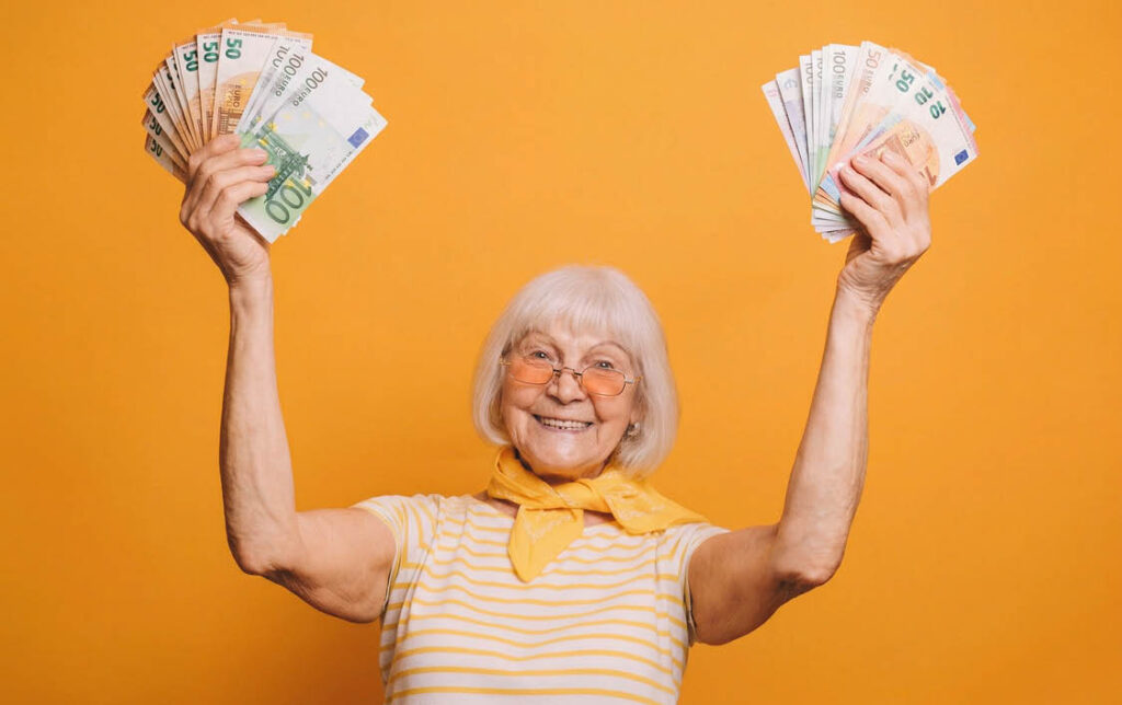 Startseite 15 Gut gelaunte 75 jährige Frau hält Euroscheine in die Höhe
