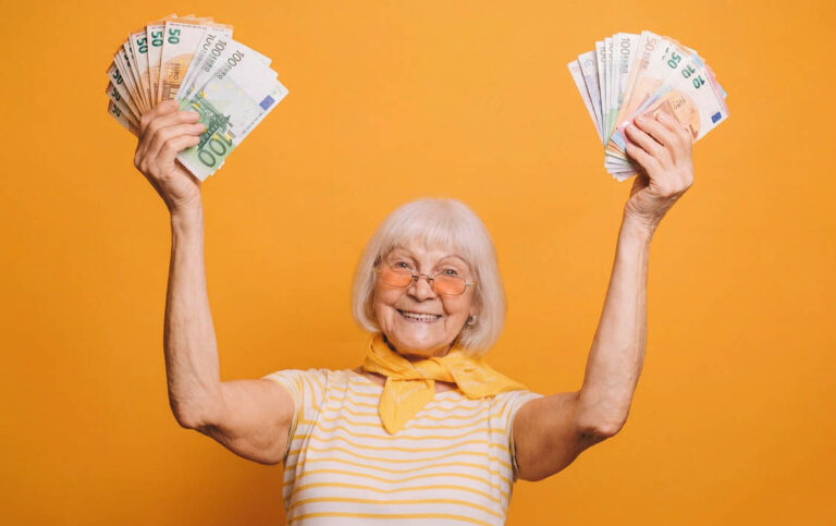 Gut gelaunte 75 jährige Frau hält Euroscheine in die Höhe