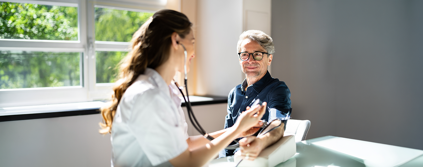 Eine Ärztin führ einen Gesundheits-Check bei einem Mann durch.